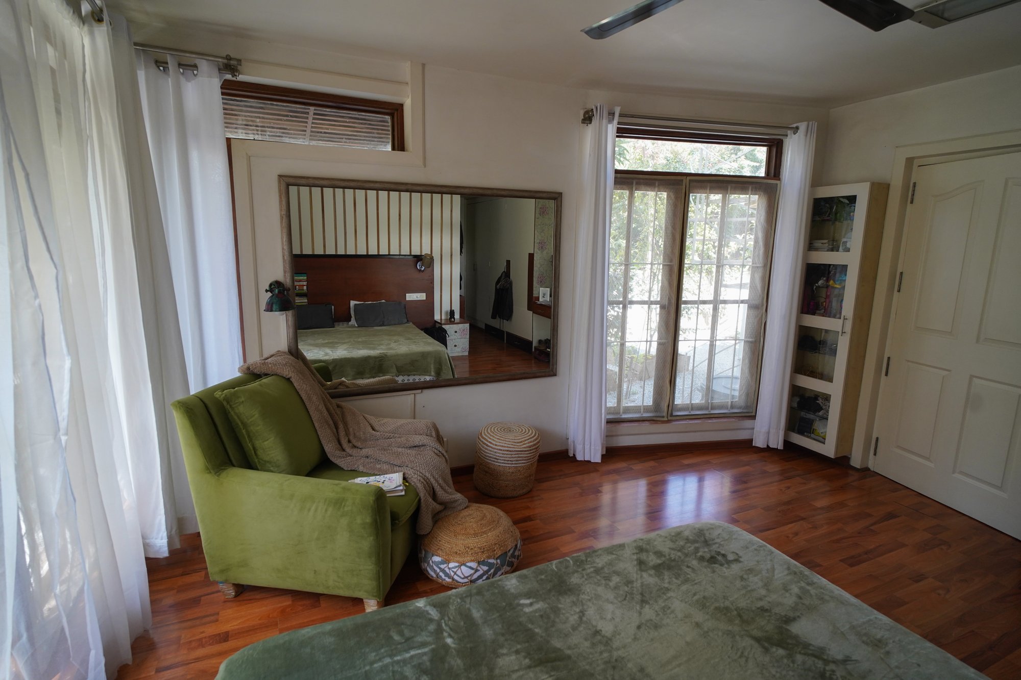 Sunlit bedroom interior with timber flooring