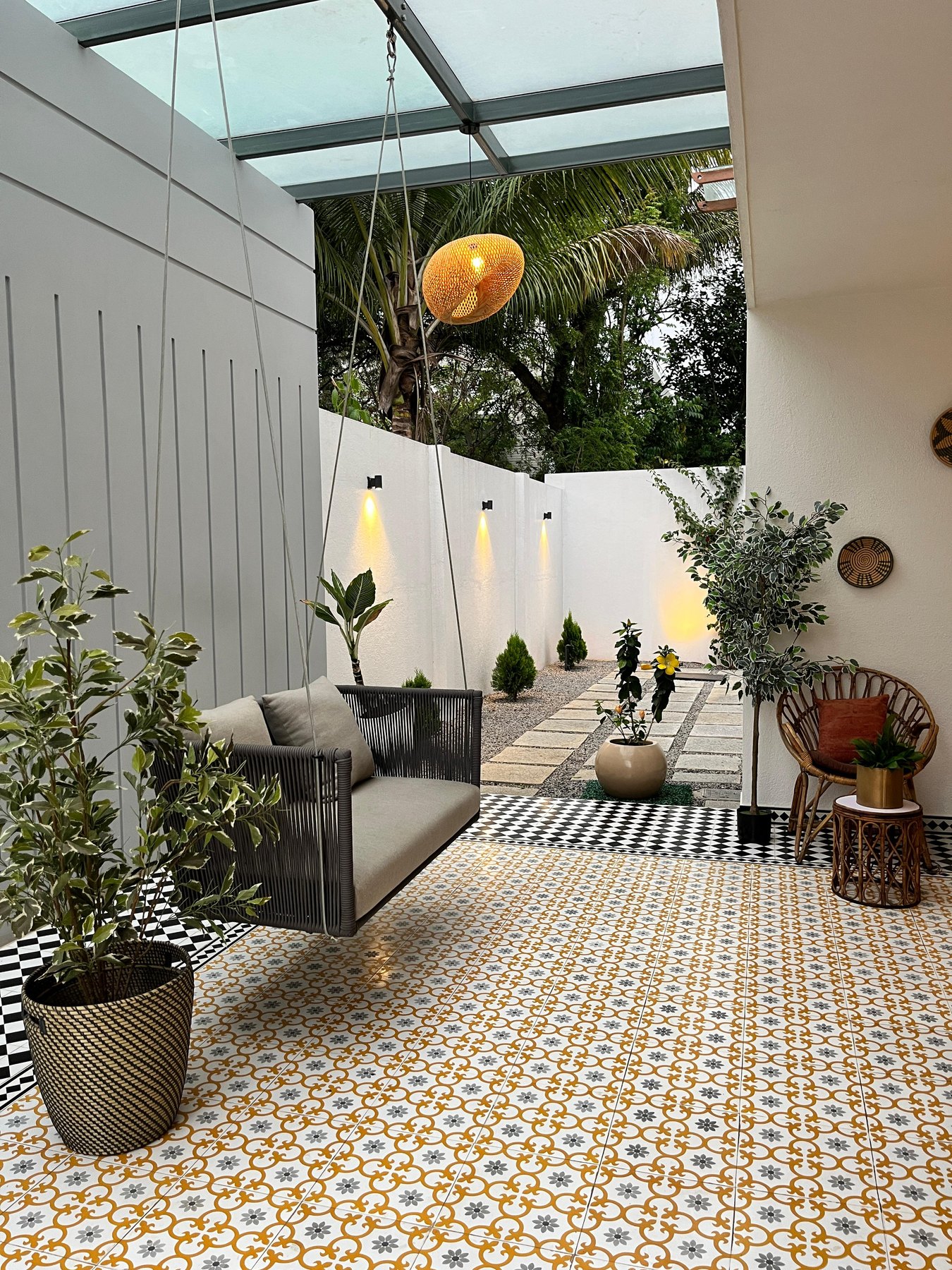 Tiled courtyard with hanging swing seat and planting
