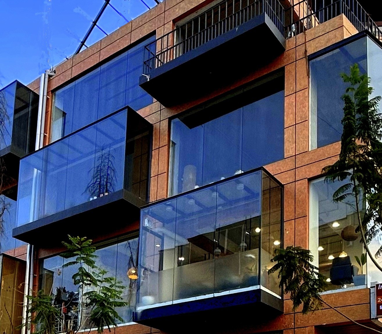 KMU Mixed Commercial — completed building, ground-floor salon signage and glazing