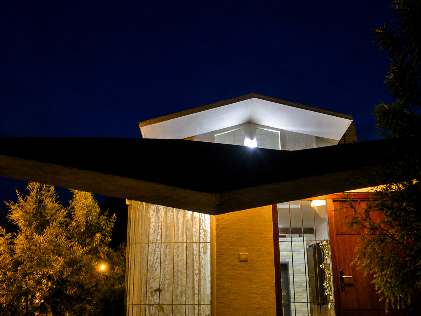 Cedar House — close night view of the inverted inclined roof planes