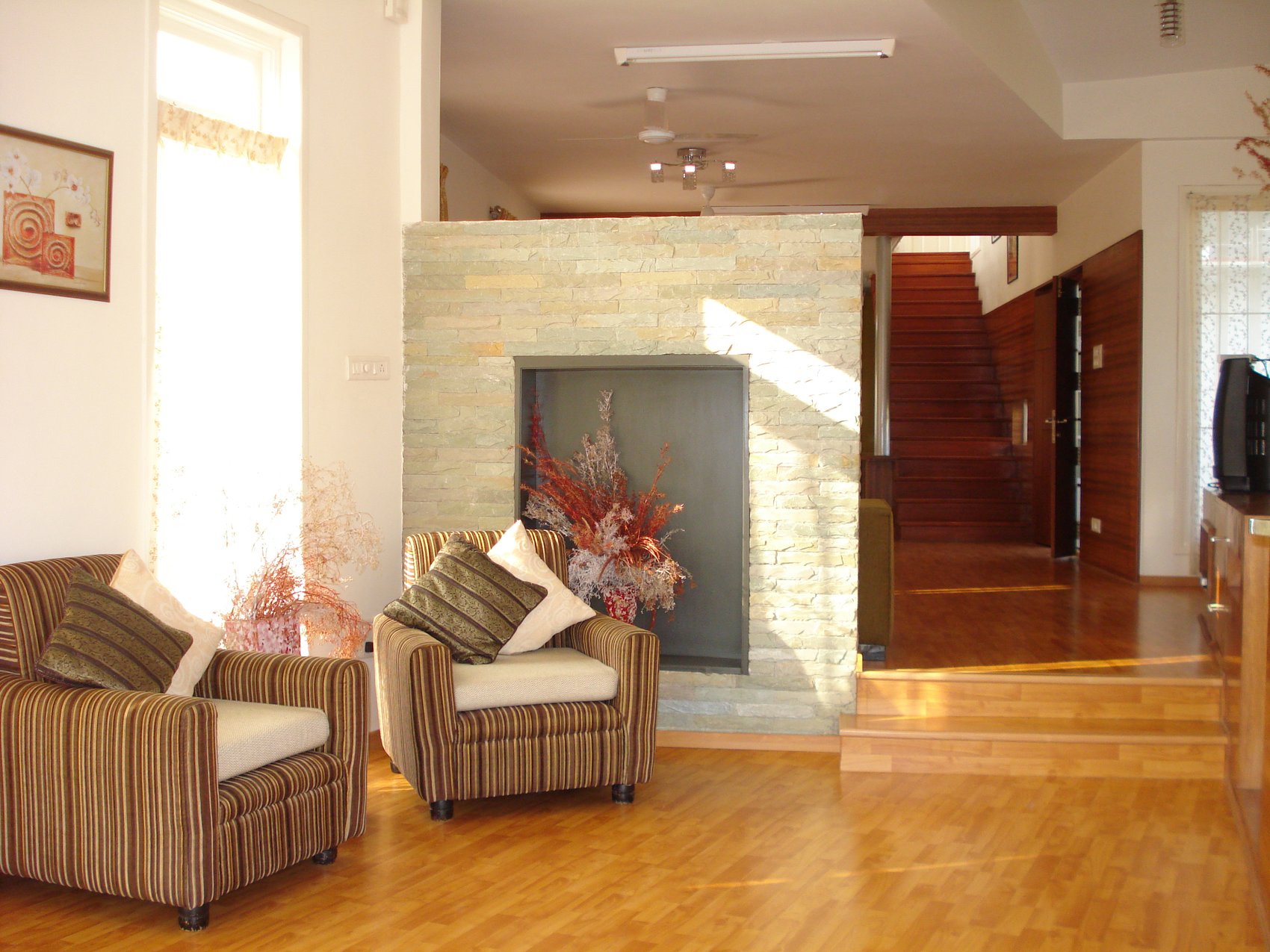 Cedar House — living room with stone-clad fireplace nook and cedar ceiling beams