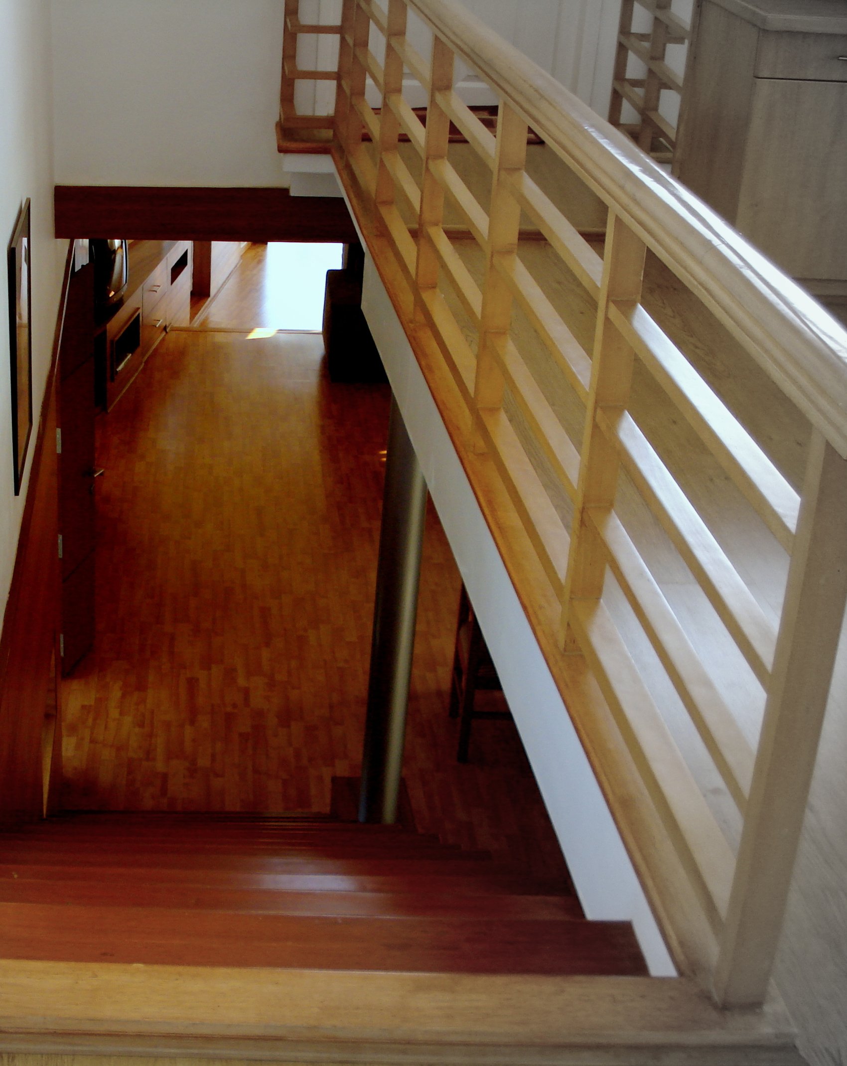 Cedar House — stairwell with cedar lattice railing looking down to the ground floor