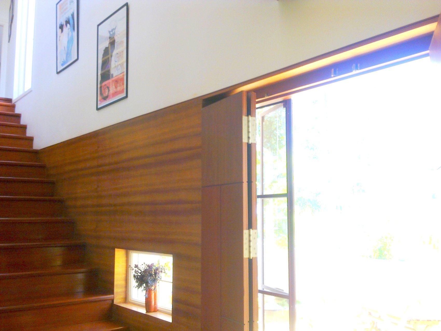 Cedar House — upper stairwell landing with framed art and window niche