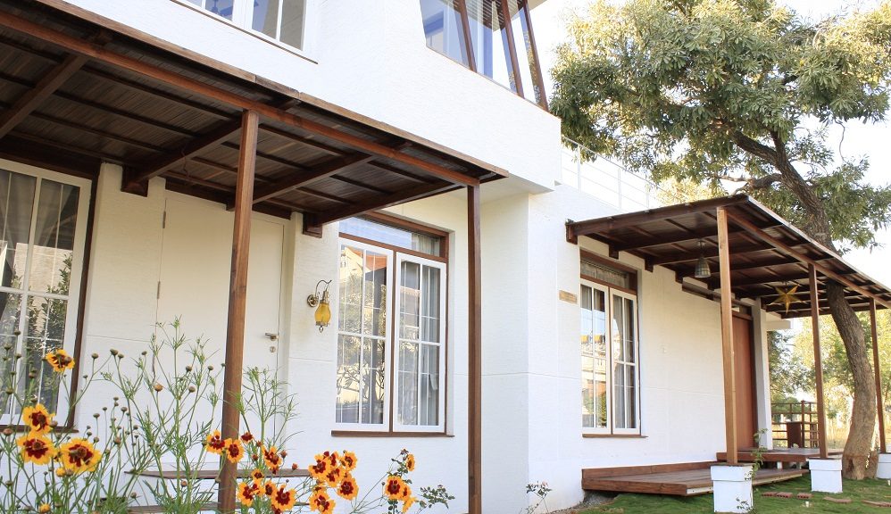 TA House — white blockwork verandah with bamboo-screen roof and coreopsis in bloom