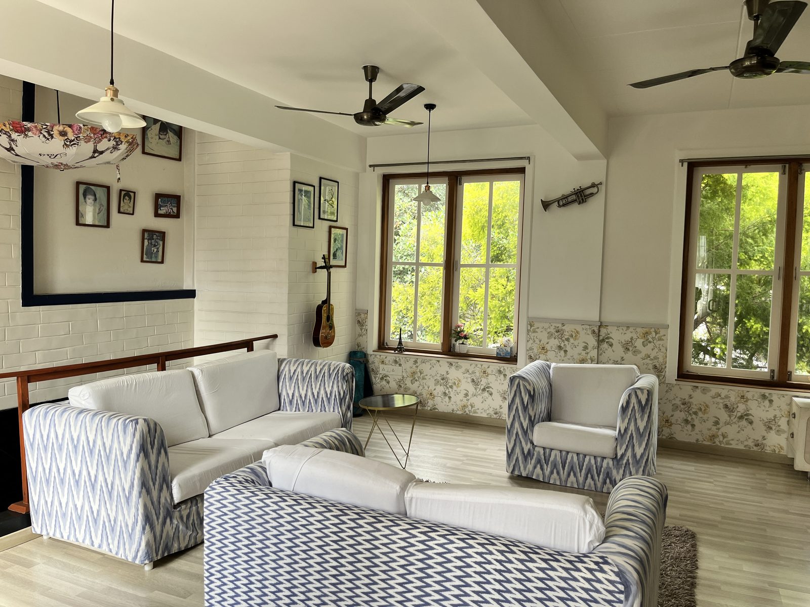 TA House — upstairs sitting room with ikat slipcovered sofas and family photo wall