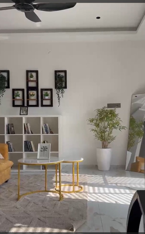 Smart City Bidadi villa — living room with built-in shelving and marble floors